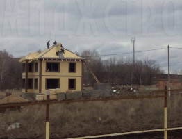 Двухэтажный коттедж с мягкой кровлей.