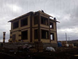 Двухэтажный коттедж с мягкой кровлей.