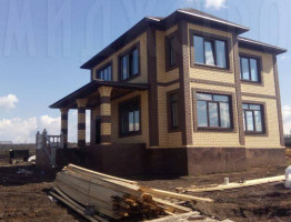 Двухэтажный коттедж с мягкой кровлей.