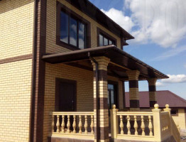 Двухэтажный коттедж с мягкой кровлей.