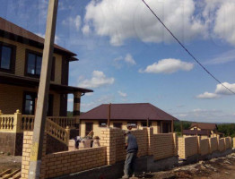 Двухэтажный коттедж с мягкой кровлей.