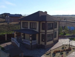 Двухэтажный коттедж с мягкой кровлей.