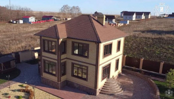 Двухэтажный коттедж с мягкой кровлей.