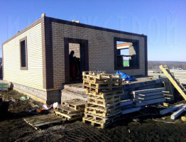 Двухэтажный коттедж с мягкой кровлей.